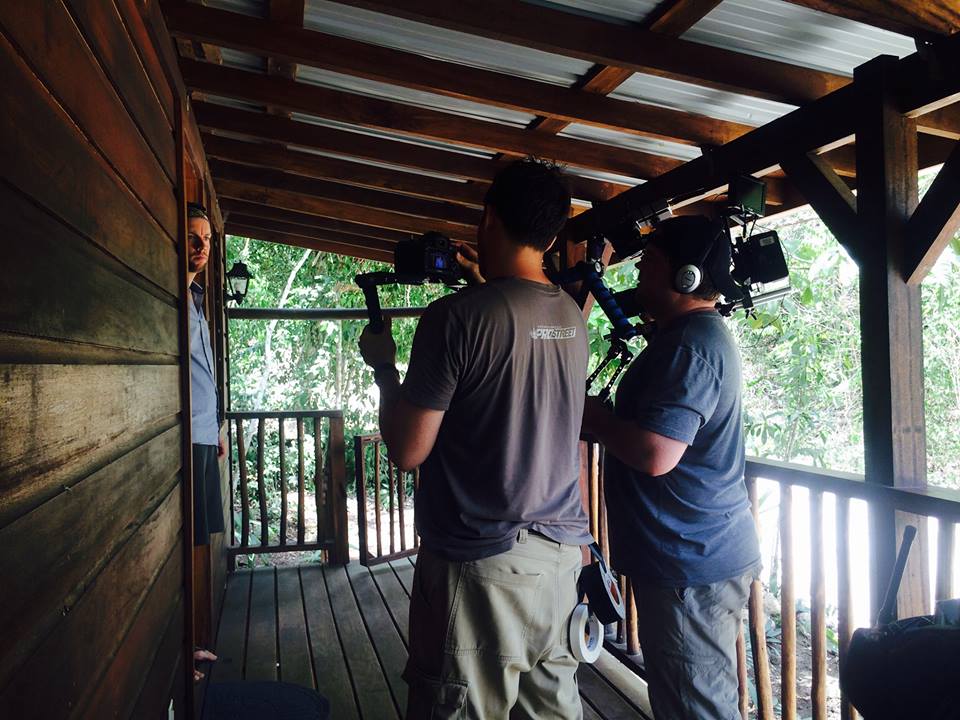 Camera crew filming on the wooden verandah of a Better in Belize home during House Hunters Off the Grid