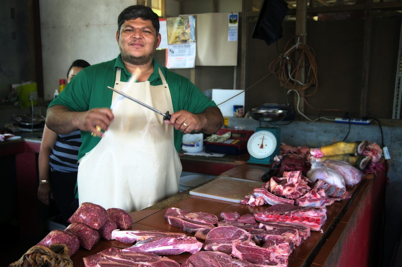 Local butcher with fresh cuts of meat at a Cayo market